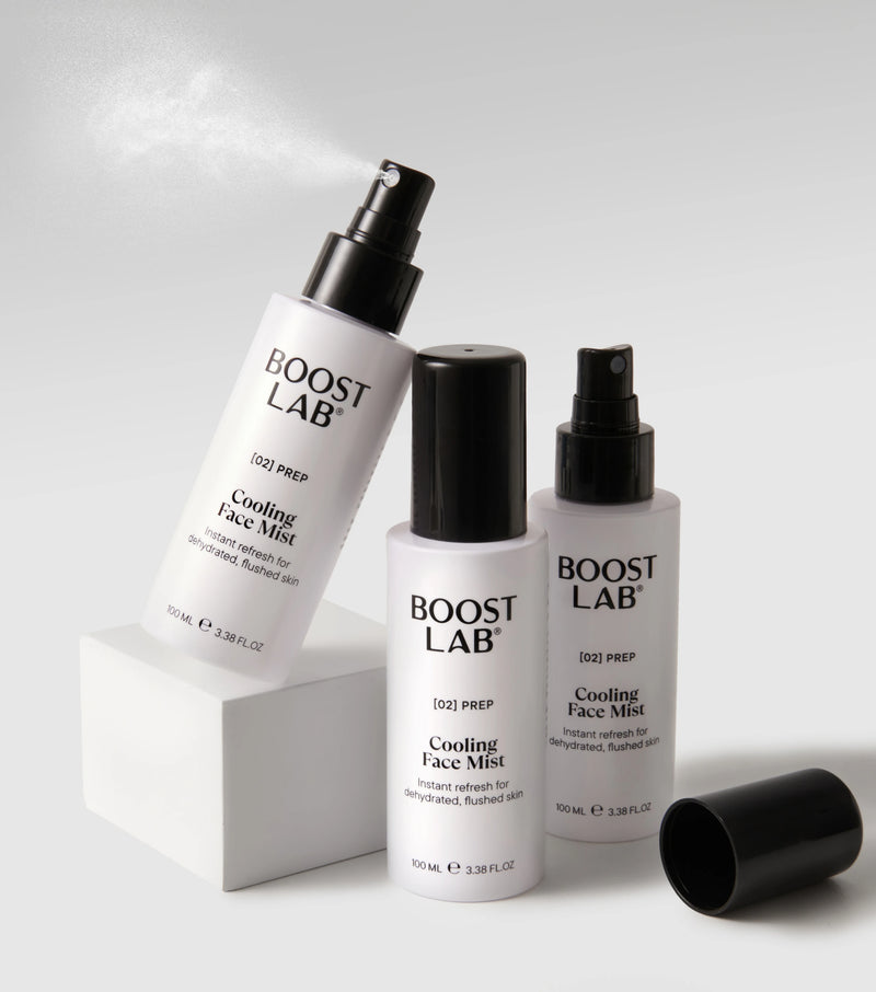 Boost Lab Cooling Face Mist spraying from a white plinth, with a second bottle and cap beside it