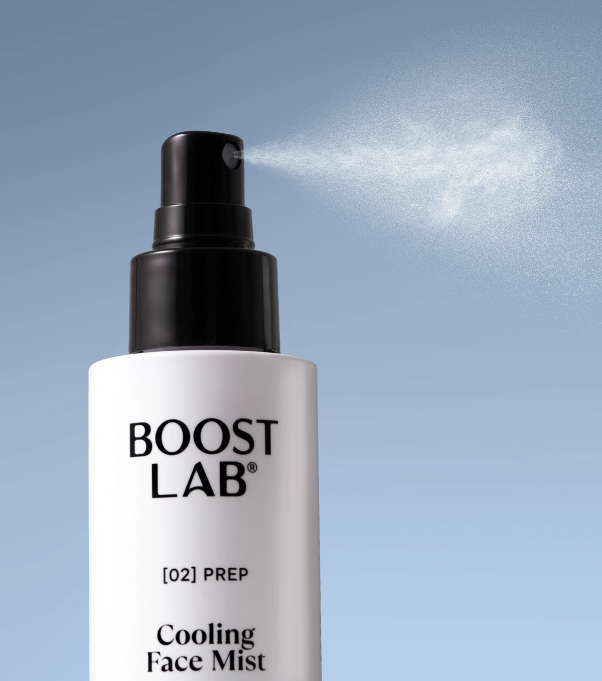 Close-up of Boost Lab Cooling Face Mist spraying a fine hydrating mist against a blue background