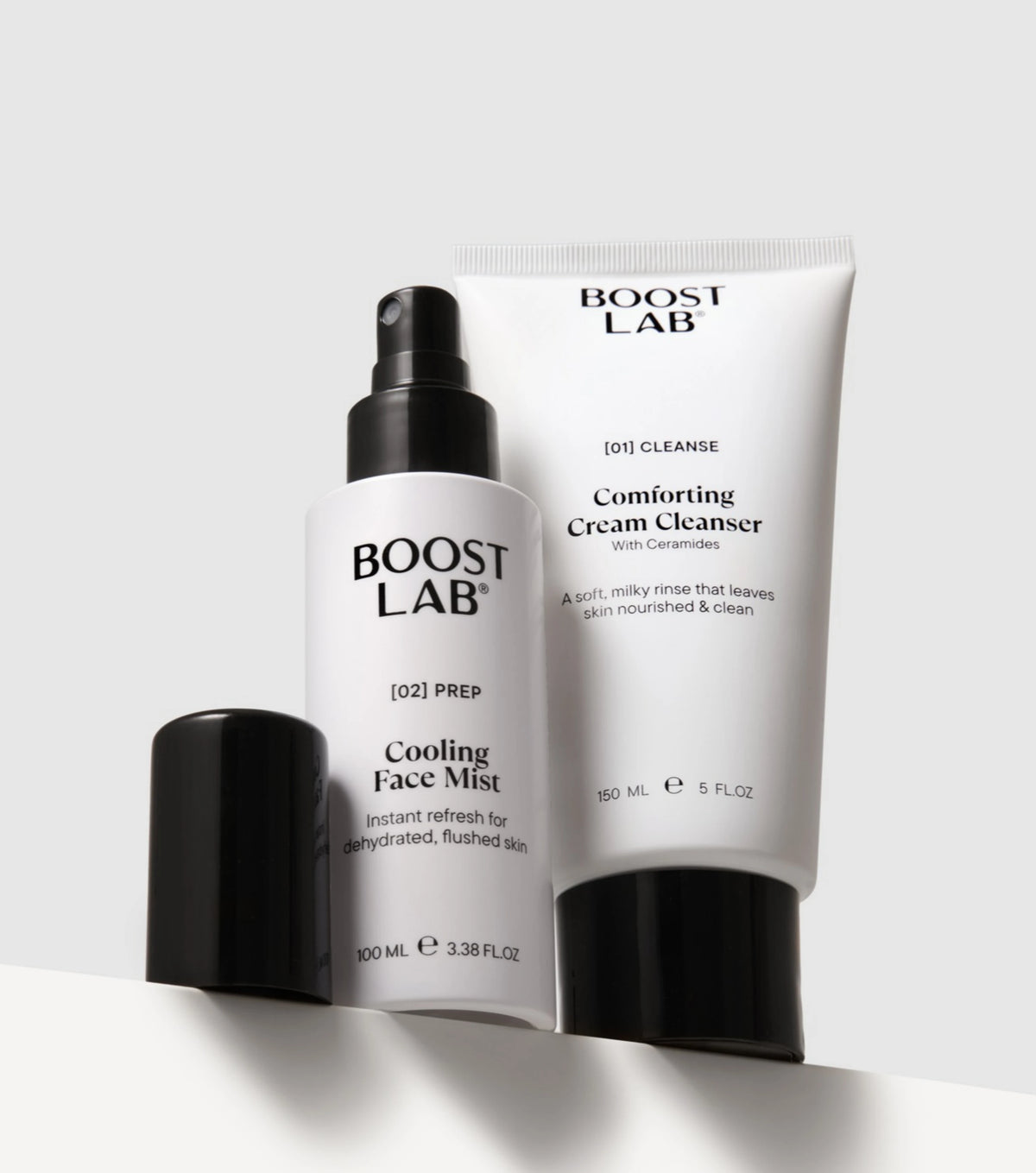 Boost Lab Cooling Face Mist and Comforting Cream Cleanser standing upright with their black caps removed